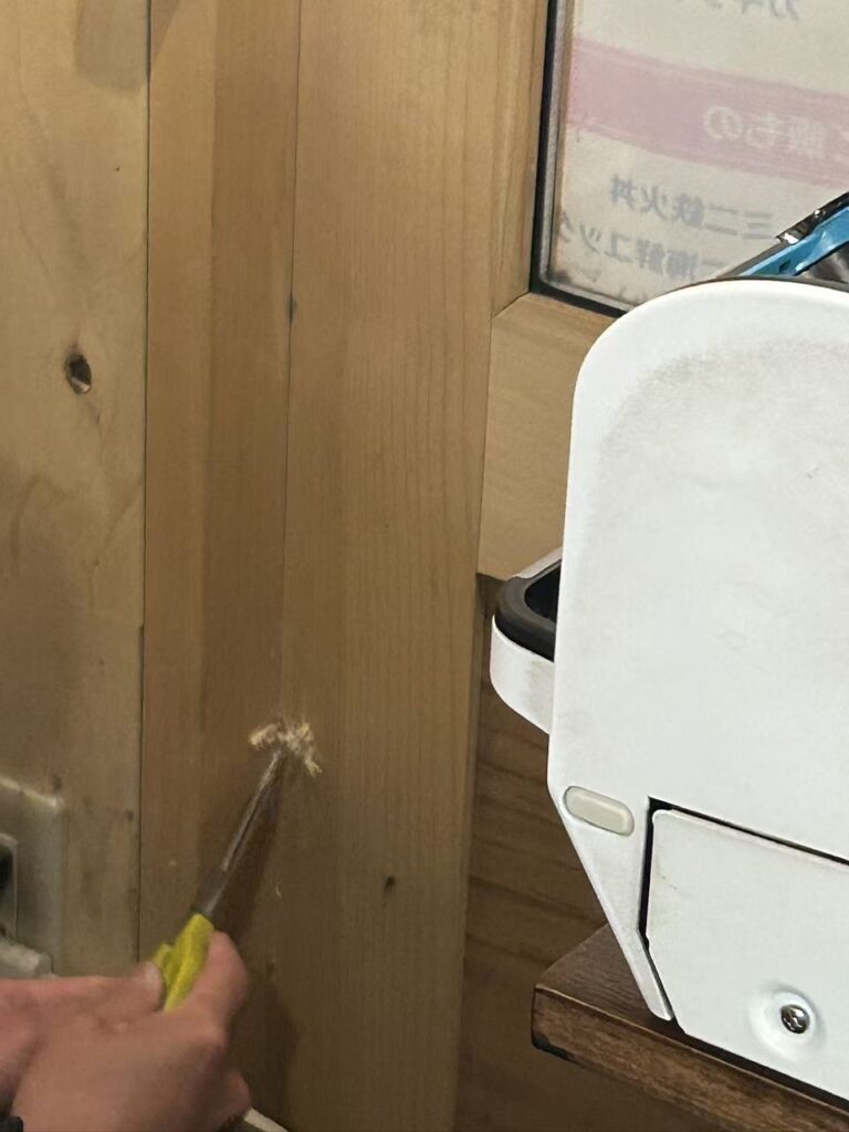 キューブの電源確保のためにお店のドアに穴を空けている作業